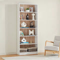 White MDF bookcase with open shelves and woodgrain back panel, filled with decor and books