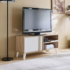 TV stand with TV centered; light wood base, white door at left and open storage at right