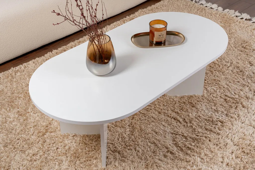 Side view of oval white coffee table with smooth MDF top and slender legs