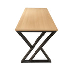 Light wood MDF desk with black metal base, angled view of X-shaped legs
