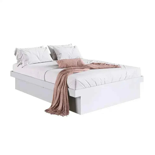 White MDF bed with low base, pillows and taupe throw draped over edge