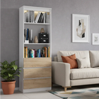 White bookcase with open shelves and light wood drawer fronts, storing books and decor