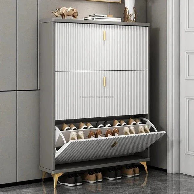 Shoe cabinet with ribbed doors, two stacked compartments and open drawer holding shoes