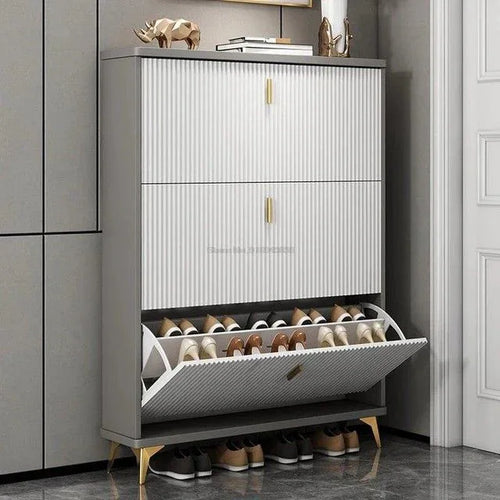 Shoe cabinet with ribbed doors, two stacked compartments and open drawer holding shoes