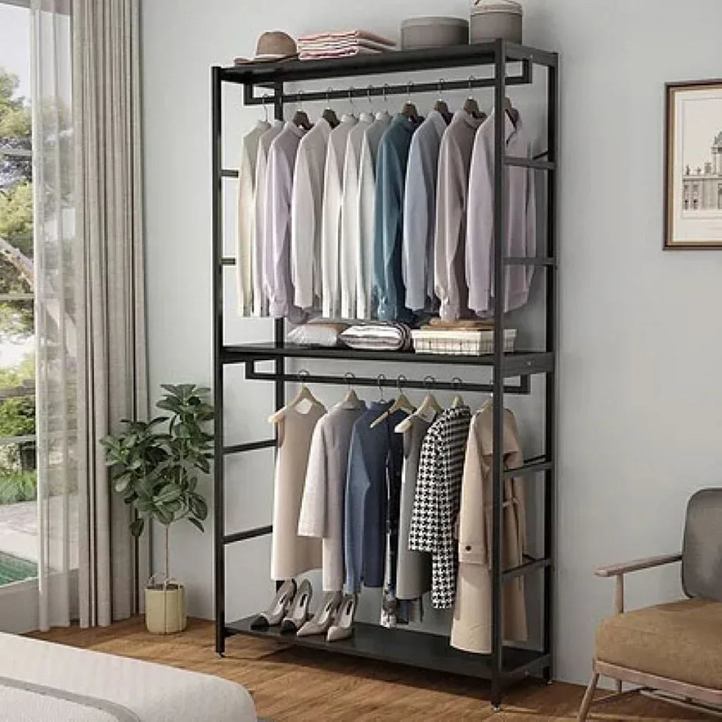 Metal clothes stand with shelves and hanging bar, holding shirts and pants