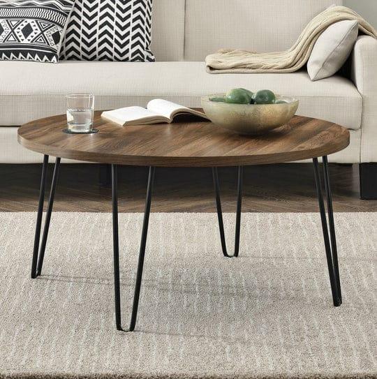 Round coffee table with dark wood MDF top and black metal four-leg base