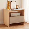 Wooden nightstand with books, alarm clock, and decorative items on a wooden floor.